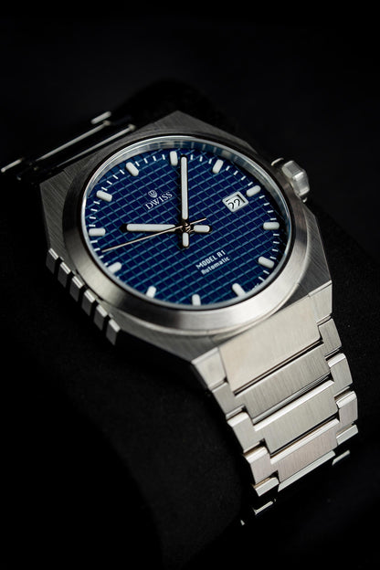 Luxury Silver watch with blue face on a black background. Model DWISS A1- using a Swiss made automatic movement La Joux-Perret G100 Soigné with 68 hours power reserve and white superLumiNova blocks