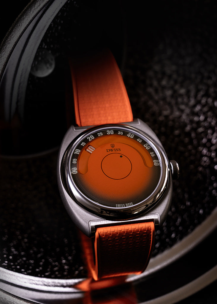 DWISS S1 Wandering Hours Naranja con esfera de fume gradiente negro. Un cierre de un reloj de pulsera con una caja de plata, un dial de naranja brillante, y una correa de naranja, descansando en un fondo circular de textura oscura.