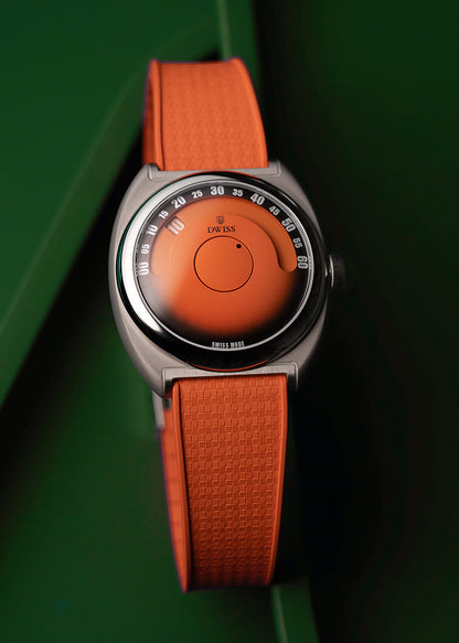 DWISS S1 Wandering Hours Orange with black gradient fume dial, a wristwatch with a textured orange strap and a matching orange dial, featuring a silver-toned round case and a black outer bezel with white markings, set against a dark green background.